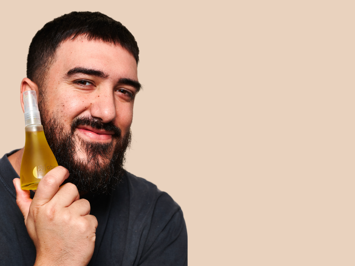 Person in a black shirt holding a bottle of oil.