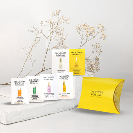 The Jojoba Company product packaging on a light gray background with decorative branches.