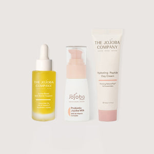Three skincare products from The Jojoba Company on a light gray background